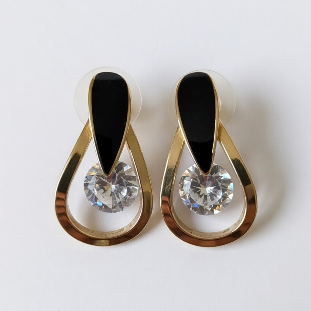Pair of earrings with gold and black design on a white background