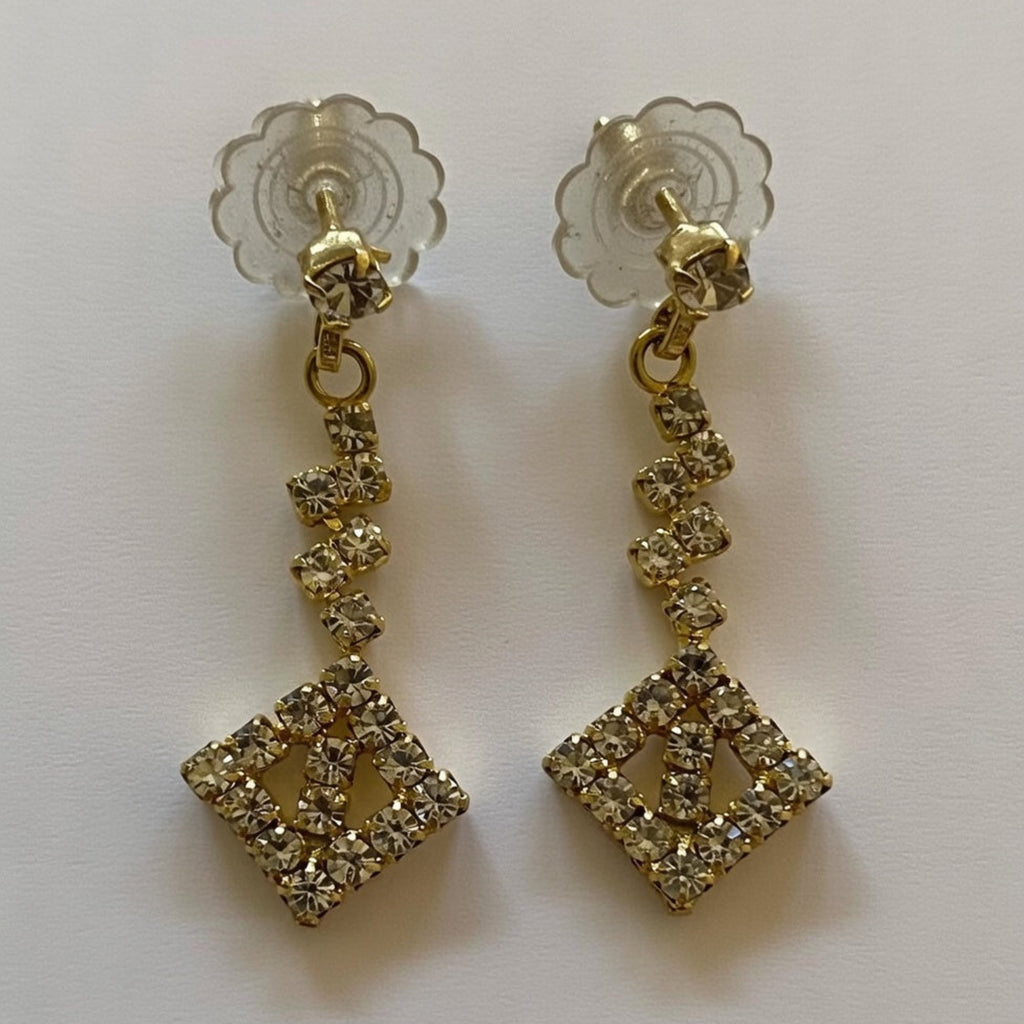Gold earrings with diamond-like stones on a white background
