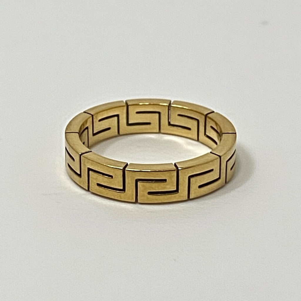 Gold ring with a geometric pattern on a white background
