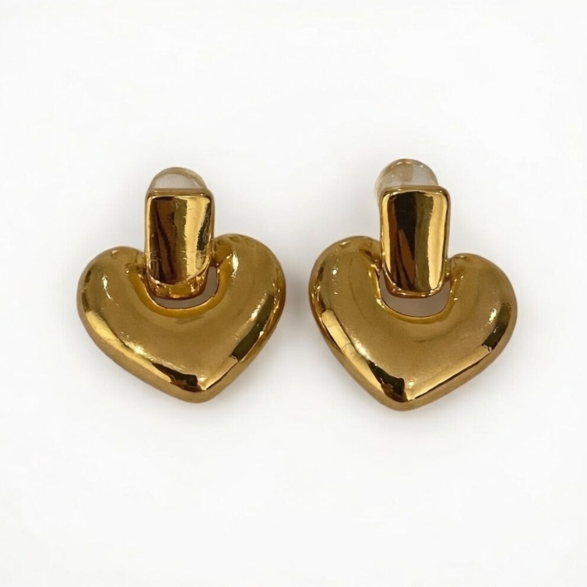 Pair of gold heart-shaped earrings on a white background