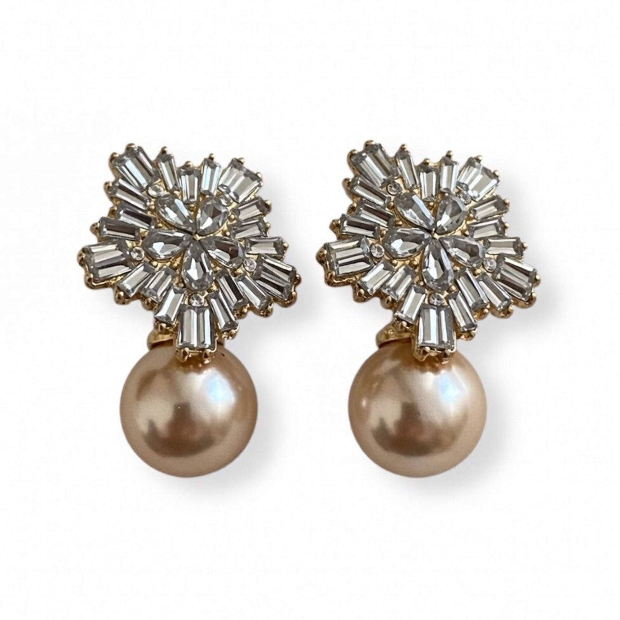 Pair of earrings with crystal embellishments and pearl drops on a white background