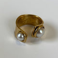 Gold ring with two pearls on a white background