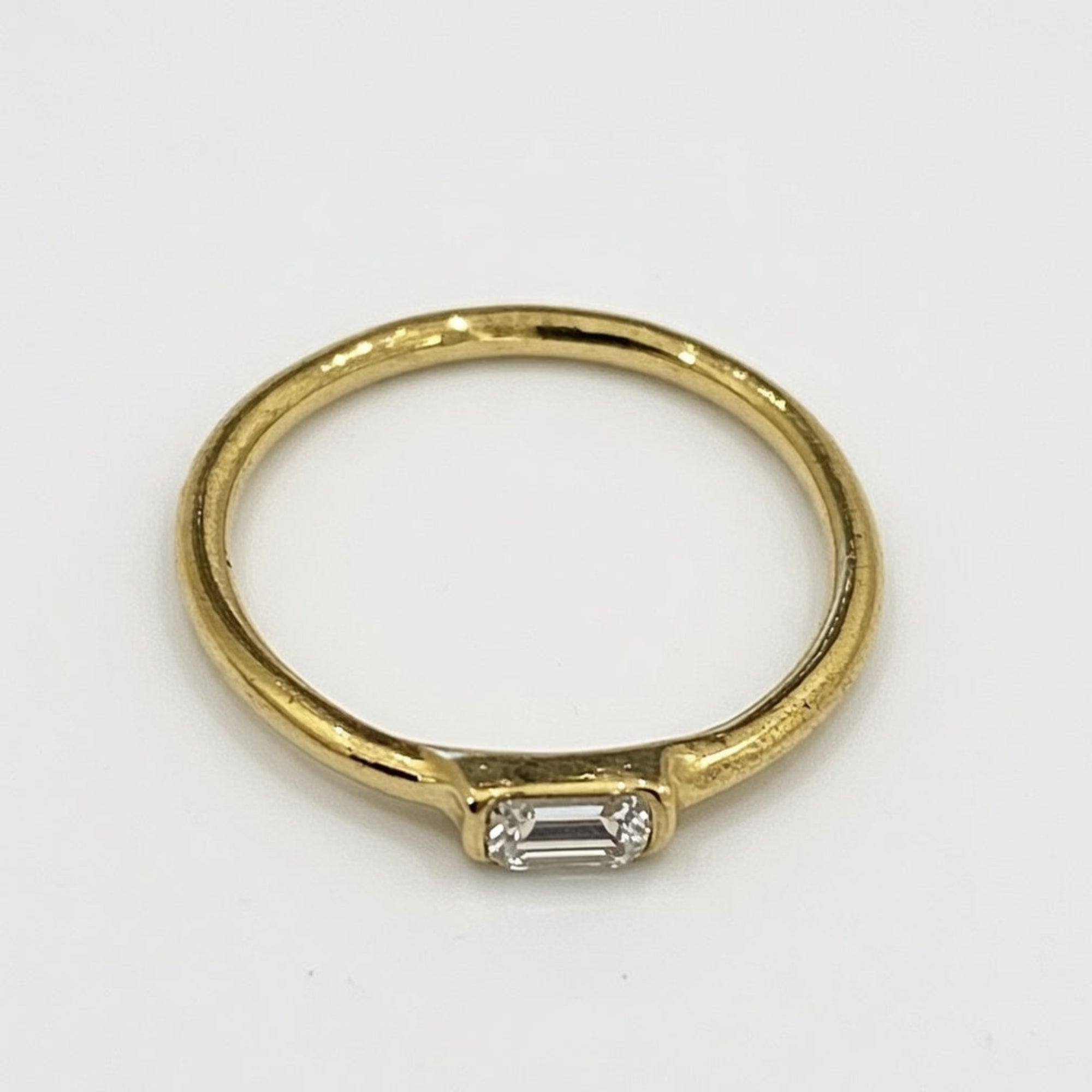 Gold ring with a diamond on a white background