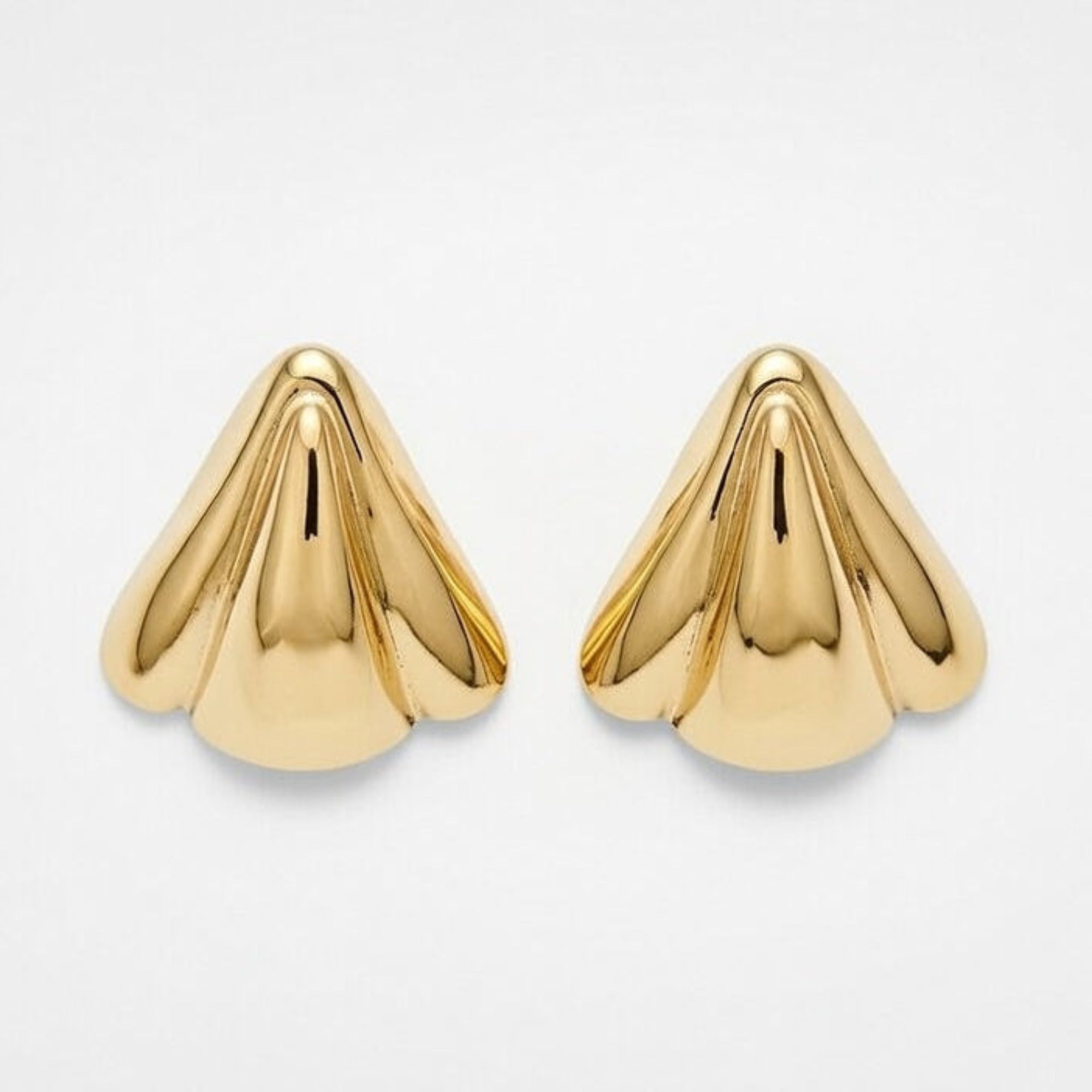 Pair of gold cone-shaped earrings on a light gray background