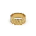 A gold-colored metal ring with a textured, wavy pattern on its outer band, shown against a plain white background.