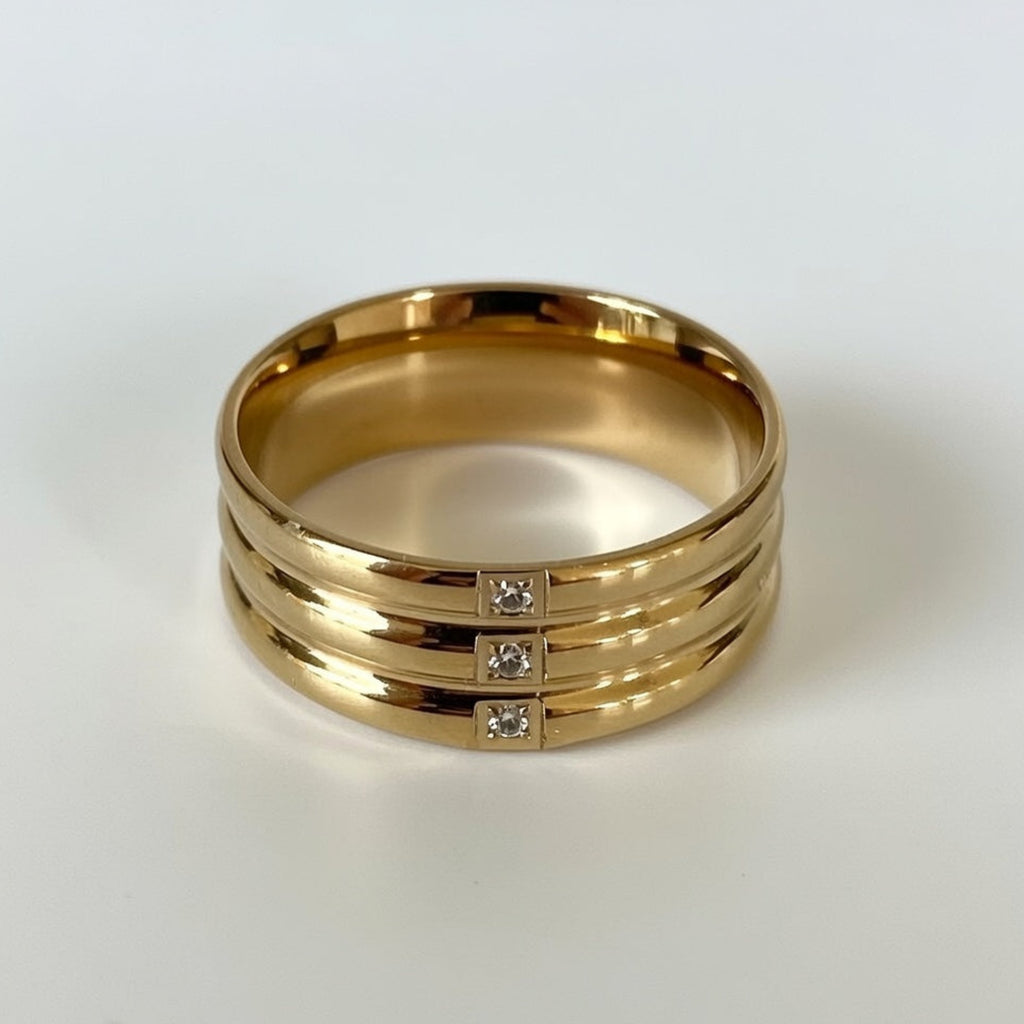 Gold ring with three diamond stones on a white background