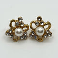 Pair of gold earrings with pearl centers on a white background