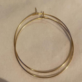 Gold hoop earrings on a beige background