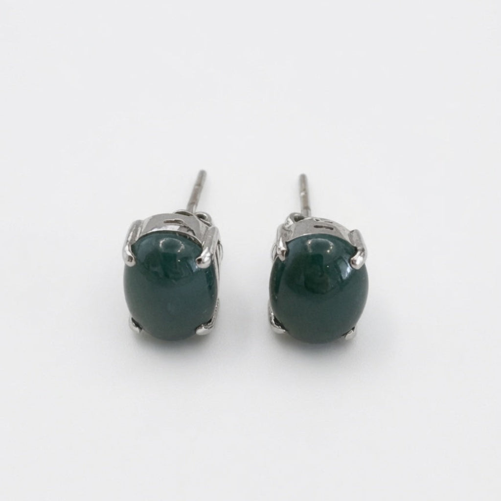 Pair of green gemstone stud earrings on a white background