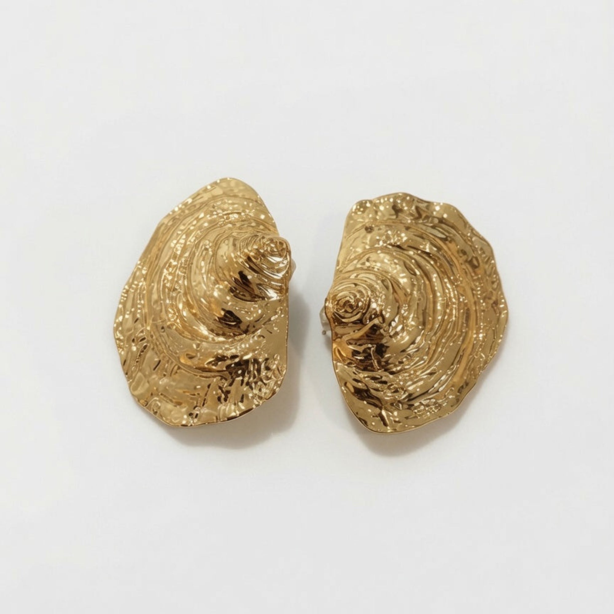 Pair of gold shell-shaped earrings on a white background